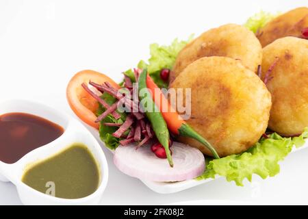 Alo Tikki, conosciuto anche come Alu Ki Tikkia, è condito Frittatine o frittatine di patate bollite usate in vari indiani Cibo di strada Masala Chaat spuntini Foto Stock