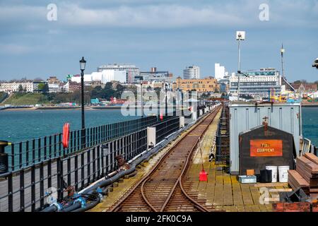 Southend on SEA Pier, Essex, UK, in primavera, guardando lungo la linea ferroviaria con persone a piedi, avvolto contro il freddo. Foto Stock