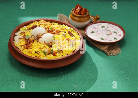 Biryani d'uovo, Biryani in stile kerala fatto con riso di jeera e spezie sistemate in una terrena con raitha e sottaceti di limone come contorno di tex ongreen Foto Stock