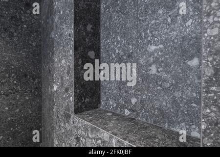 Bagno moderno minimalista con interni dal design scuro e piastrelle di pietra scura Foto Stock