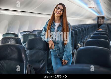 Gladsome donna dai capelli lunghi in posa nel velivolo vuoto Foto Stock