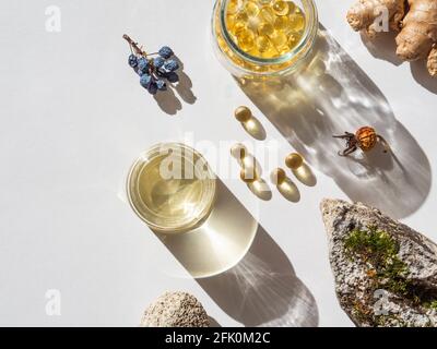 Prodotto naturale organico - oli e varie piante secche per la salute su sfondo bianco alla luce del sole. Medicina alternativa alle erbe e aromaterapia. Da a. Foto Stock