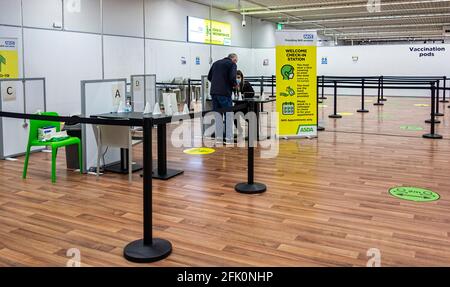 NHS Covid-19 vaccination Center at Asda, Watford Hertfordshire UK - Maschile Waiting at Covid-19 check in station Foto Stock