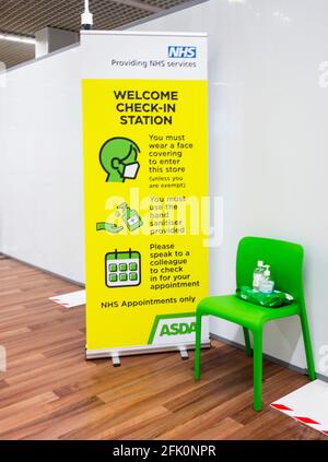 NHS Covid-19 Vaccination Center at Asda, Watford Hertfordshire UK - cartello di benvenuto della stazione di check-in Foto Stock