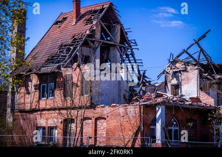 20 aprile 2021, Meclemburgo-Pomerania occidentale, Malliß: In parte senza tetto e con pareti crollate, sorge l'edificio dell'ex ristorante 'Fritz-Reuter-Krug' sulla strada principale. Nelle prossime settimane, la rovina sarà ora abbattuta. L'edificio storico è stato usato come locanda dal 18 ° secolo. L'edificio è vuoto da 21 anni ed è stato infine distrutto in un incendio nel gennaio 2015. Foto: Jens Büttner/dpa-Zentralbild/ZB Foto Stock