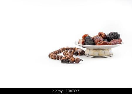 Datteri o frutta kurma e rosari o Tasbih su sfondo bianco. Ramadan Kareem e concetto islamico Foto Stock