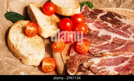 Fette di pane, pomodori ciliegini, spinaci e prosciutto. Ingredienti Foto Stock