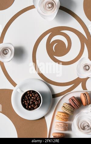 Chicchi di caffè in tazza, macaron, cerchi di sequenza Fibonacci. Espresso, gustosa perfezione. Concetto di rapporto d'oro, arte della carta Vista dall'alto in due tonalità, bianco Foto Stock