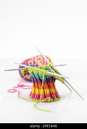 Lana multicolore con lavorazione a maglia su sfondo bianco Foto Stock