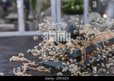Composizione pasquale con uova di colore scuro in una scatola di legno. Filiale Willow. Il concetto minimo di Pasqua. Una carta di Pasqua con un posto per il testo. Foto Stock