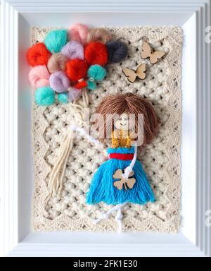 Immagine macrame fatta a mano in cornice raffigurante ragazza con colorato baloon su sfondo intrecciato Foto Stock