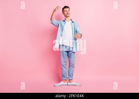 Foto a tutta lunghezza del corpo di una ballerina seria in piedi in posizione dance guardando copyspace isolato su colore rosa pastello sfondo Foto Stock