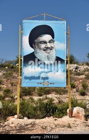 Cartello con il Segretario Generale di Hezbollah Sayyed Hassan Nasrallah con posto dell'UNIFIL alle spalle, Marwhien, Libano meridionale. Foto Stock