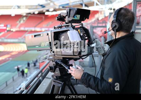 Norimberga, Germania. 27 Apr 2021. Calcio: 2. Bundesliga, 1. FC Nürnberg - Holstein Kiel, 29. giornata al Max-Morlock-Stadion. Un cameraman con maschera al lavoro. NOTA IMPORTANTE: In conformità con le norme del DFL Deutsche Fußball Liga e del DFB Deutscher Fußball-Bund, è vietato utilizzare o utilizzare fotografie scattate nello stadio e/o della partita sotto forma di sequenze di immagini e/o serie di foto simili a video. Credit: Daniel Karmann/dpa/Alamy Live News Foto Stock