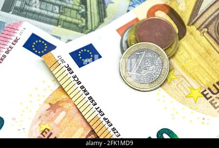 Una moneta in euro su alcune banconote di valore diverso. L'euro è la moneta europea. Finanza, economia e imprese. Contanti e risparmio Foto Stock