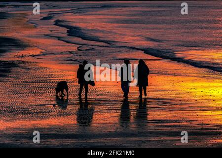 Una passeggiata attraverso le onde dipinte dai colori del tramonto. Foto Stock