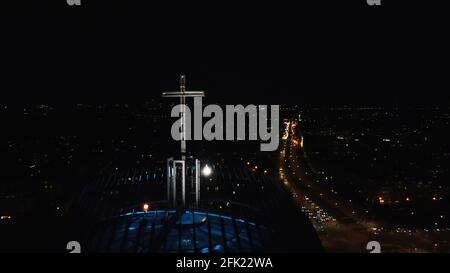 Varsavia, Polonia 12.01.2020 - Città di notte. Primo piano di croce all'edificio della Chiesa. La vita notturna di Varsavia. Strada trafficata con veicoli in funzione. Il cielo jet-black sullo sfondo. Foto Stock