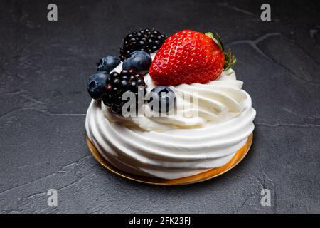 Il dessert Pavlov con panna bianca e frutta Foto Stock