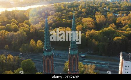 Varsavia, Polonia 12.01.2020 - Vista aerea delle torri gemelle della Cattedrale di San Michele Arcangelo e di San Florian il Martire. Luce del sole che colpisce i lussureggianti alberi verdi sullo sfondo. Lo scatto viene effettuato durante la sera. Foto Stock