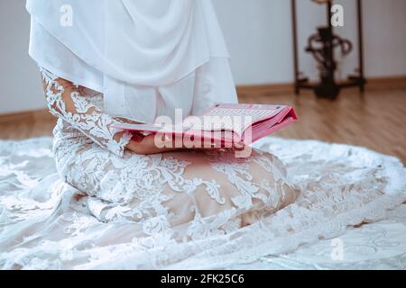 Primo piano di un giovane musulmano che legge il Corano, il sacro libro islamico Foto Stock