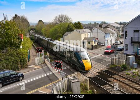 Pencoed, vicino a Bridgend, Galles - Aprile 2021: Treno ad alta velocità che passa sopra l'attraversamento del livello nel villaggio di Pencoed. Foto Stock