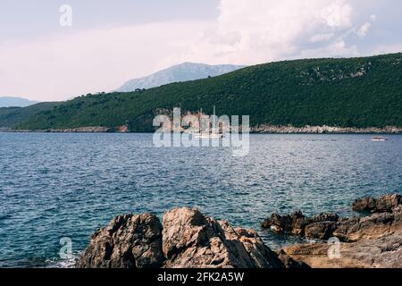 Yacht bianco a due alberi naviga sul mare lungo le colline costa Foto Stock