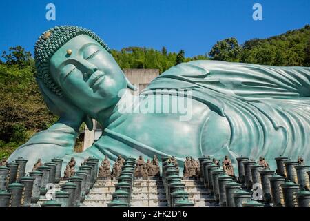 Tempio buddista Nazoino con Buddha sdraiato. Cielo blu e statua turchese che giace sul suo lato. Buddha più lungo del mondo. Fukuoka, Giappone Foto Stock