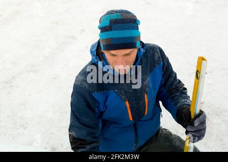 Lo scultore tagli una figura di ghiaccio al di fuori del ghiaccio con uno scalpello per Natale Foto Stock