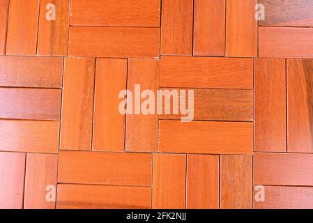 Un bell'esempio di parquet in mogano rosso in una vista prospettica che crea un'immagine di sfondo. Foto Stock