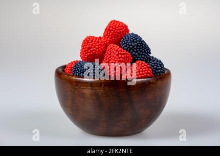 Caramelle gommiche ricoperte di fragola e mirtillo su bianco Foto Stock