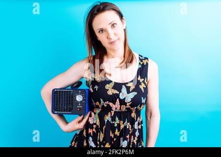 bella giovane donna adulta in farfalla estate vestito guardare avanti tenendo una macchina ozono. concetto di disinfezione della casa con ozono. vacanze. co Foto Stock