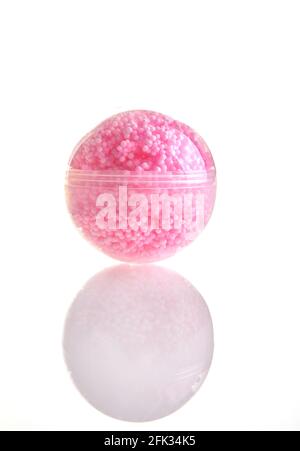 Palla trasparente con molte palline rosa all'interno, giocattolo per bambini isolato su sfondo bianco Foto Stock