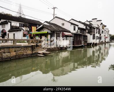 Suzhou, Cina - 23 marzo 2016: Canale d'acqua nella città vecchia di Suzhou fiancheggiata da bianche case murate all'estremità nord della strada di Pingjiang Foto Stock