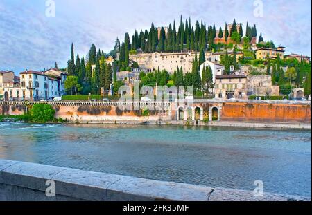 Goditi la serata, passeggiando lungo il fiume Adige con vista sul cielo viola brillante sul colle San Pietro, Verona, Italia Foto Stock