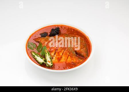 Il curry bianco del masala del pomfret, fatto nello stile dell'india del sud con salsa rossa spessa e guarnito con il peperoncino verde, le foglie del curry e il tamarindo del malabar organizzano Foto Stock