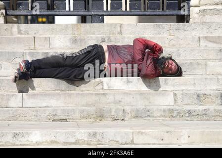 Londra, Inghilterra, Regno Unito. L'uomo addormentò sulle scale di San Martino nella Chiesa dei campi, Piazza Trafalgar Foto Stock