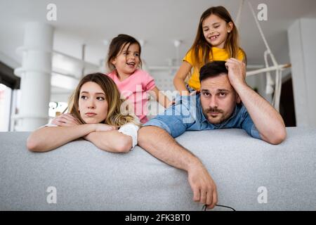 Madre stanca e padre, la coppia si sente seccata di bambini rumorosi Foto Stock