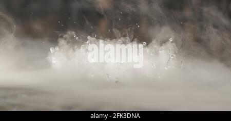 BANNER astratto. Vera nube di fumo Mystic con gocce d'acqua che esplodano, movimento del mosca del vapore, sfondo scuro. Esperimento chimico, aromaterapia, bevanda bruciata Foto Stock