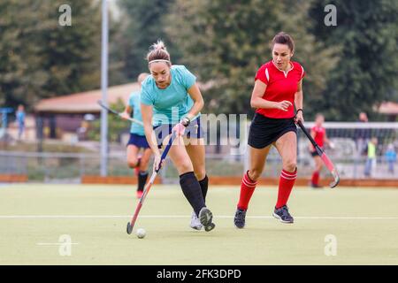 Due giocatori di hockey su campo lottano per la palla Foto Stock