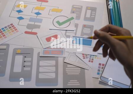 I progettisti disegnano il concetto di sviluppo di app mobile ux. Matita Man Hold con interfaccia utente mockup. Foto Stock