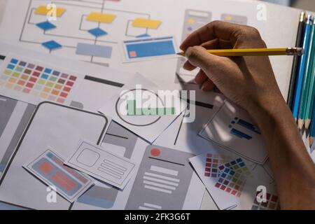 I progettisti disegnano il concetto di sviluppo di app mobile ux. Matita Man Hold con interfaccia utente mockup. Foto Stock