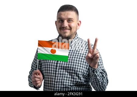 Ragazzo bianco che tiene una bandiera del Niger e mostra due dita isolate su uno sfondo bianco. Foto Stock
