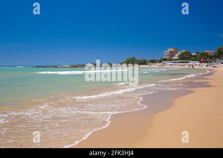 Realmonte, Agrigento, Sicilia, Italia. Vista sulla baia dalla spiaggia di sabbia, onde dolci che lambano la riva. Foto Stock