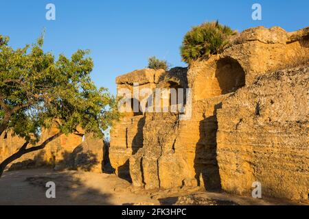 Agrigento, Sicilia, Italia. Antiche tombe rupestri che costeggiano la Via Sacra illuminata dal sole che tramonta, Valle dei Templi. Foto Stock