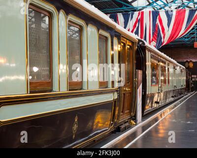 York, North Yorkshire, Inghilterra. Le carrozze dei treni reali sono esposte sotto Union Jacks al National Railway Museum. Foto Stock