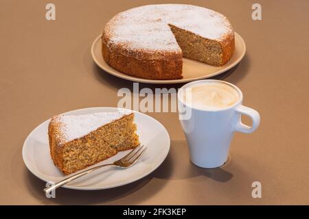 Vecchia ricetta torta fatta di mandorle e pane secco (Antica torta alle mandelle e pane) con una tazza di cappuccino Foto Stock