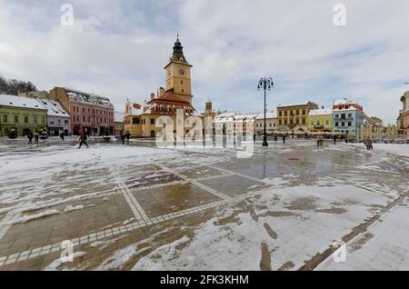 Neve di primavera nel centro storico di Brasov Romania. La famosa Casa Sfatului - conosciuta in inglese come la Casa del Consiglio - è prominente nel backgroun Foto Stock