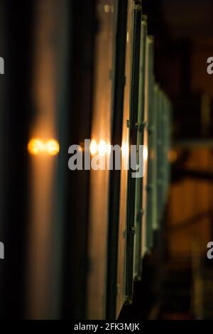 Vista astratta riflessi del corpo della macchina in metallo lucido nella retroilluminazione. Sfondo a strisce di colore caldo. Foto industriale. Foto Stock