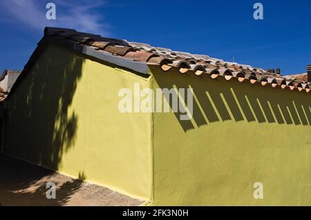 Una parete gialla di una casa con le ombre delle tegole (Pesaro, Italia, Europa) Foto Stock