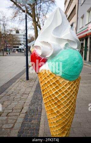 Crema di ghiaccio artificiale per waffle con Crema Toping come pubblicità Di fronte a un gelateria in UN pedonale deserto Zona Foto Stock